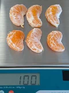 6 tangerine segments on a scale weighting 100 grams